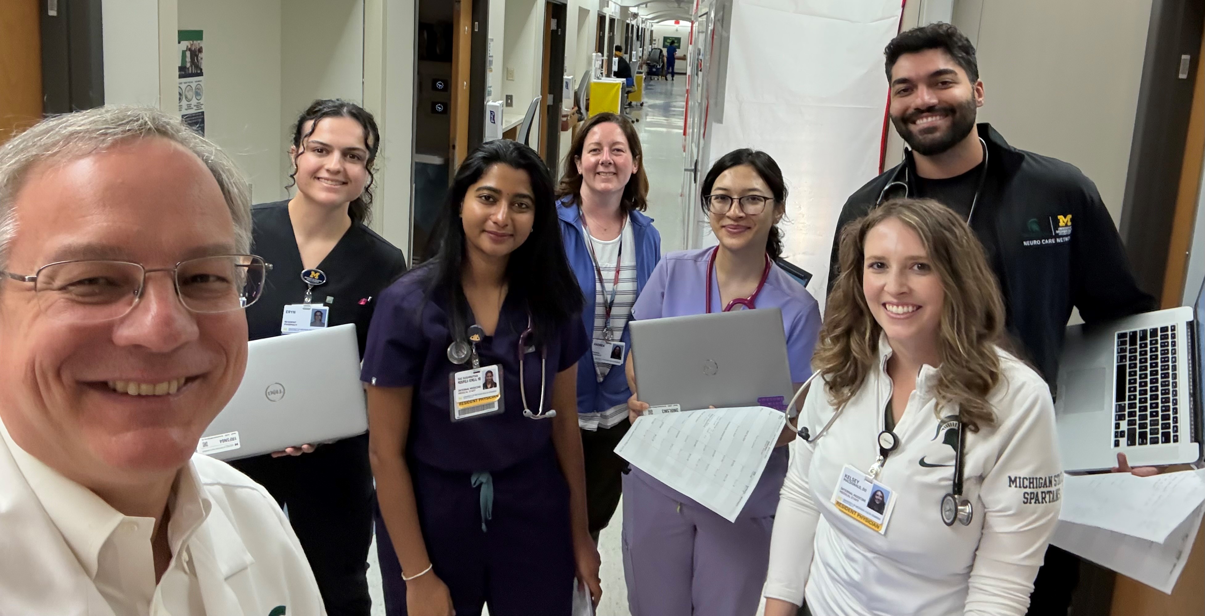 Team Sparty rounding: (l-r) Aron; pharmacy resident Eryn Isaacson, PharmD; senior resident Sai Sushrutha Muduoula Vemula, MD; pharmacist Andrea Payne, PharmD; and junior residents Angel Dongol, MD; Kelsey MacDonald, DO (front); and Arman Shojaei, DO (back).